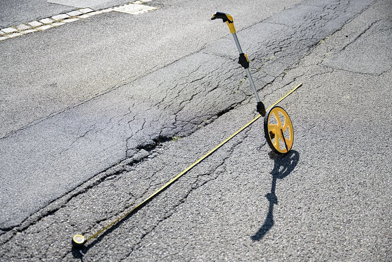 Detail eines verzweigten Risses im Strassenbelag mit Messrad